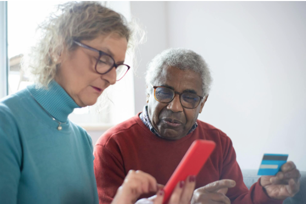 Picture of two adults looking at a cell phone